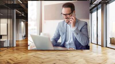  Young man working with laptop in office Wall mural