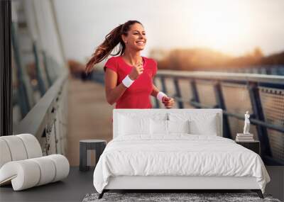 Beautiful woman running over bridge Wall mural