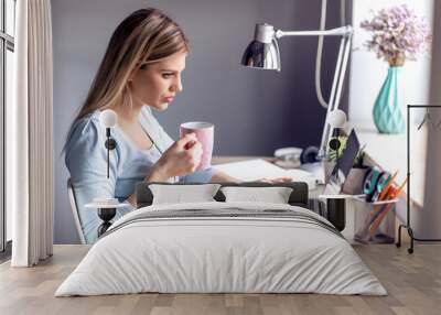 Beautiful young woman working at home office Wall mural