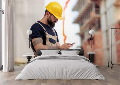 Engineer holding smart phone at construction site Wall mural