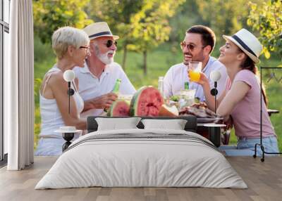 Family having lunch at summer garden party Wall mural