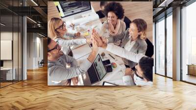 Happy business team giving high five in office Wall mural