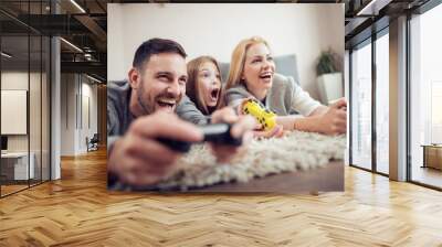 Happy family playing a video games at home Wall mural