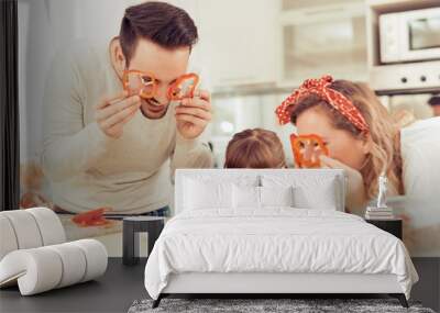 Happy young family preparing lunch Wall mural