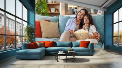 Happy young mom and her daughter watching cartoons on television Wall mural