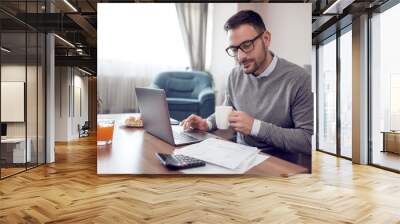 Man at home working on a laptop Wall mural