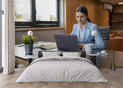 Shot of young entrepreneur woman working with laptop in the office Wall mural