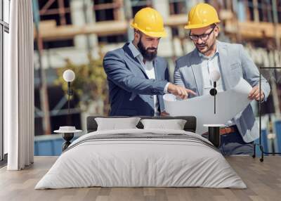 Two young architects or engineers discussing a project plan. Wall mural