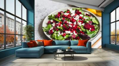 Arugula, Beet and cheese salad with pomegranate and dressing on plate on grey stone kitchen table background, place for text, top view Wall mural