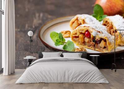 homemade fragrant strudel with apples and cinnamon on a plate on a wooden background with space for text Wall mural