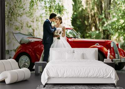 Couple on the wedding and a car on the background Wall mural