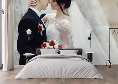 Gorgeous brunette bride hugging groom and posing near old castle Wall mural