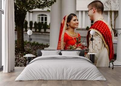 Happy indian bride and groom are looking at each other in love Wall mural