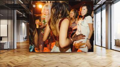 Hindu bride with henna tattoos dances on the party with her friends Wall mural