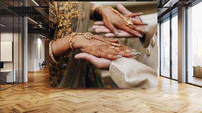 Indian bride's hands coloured with henna on the groom's hands, traditional wedding accessories Wall mural