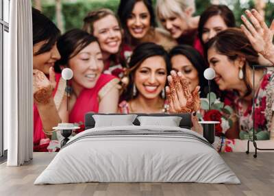 Indian bridesmaids admire beautiful bride posing together in the garden Wall mural