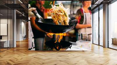 Man cooks noodles on the fire Wall mural