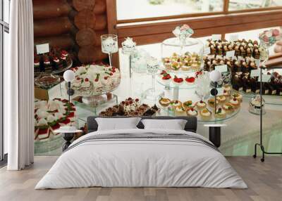 Tasty chocolate and cheese cakes stand on the glass dishes on wh Wall mural