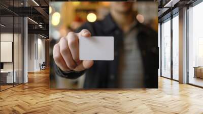 Man holding a blank white card in a café, business and contact concept Wall mural