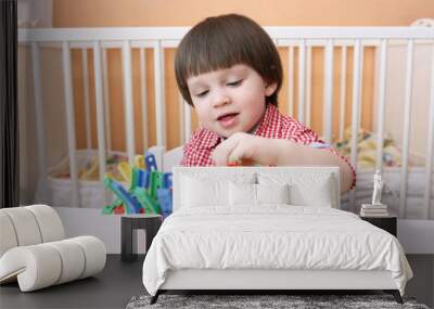 portrait of 2 years child playing with clothes pins Wall mural