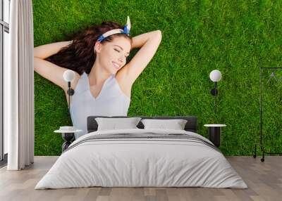 Beautiful young woman lies on the grass. Fresh natural summer concept. View from the top. Wall mural