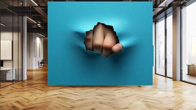 A businessman's hand protruding from a blue paper sheet Wall mural