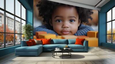 A cute African American child is shown in a lifestyle shot interacting with bright wooden block toys. Wall mural