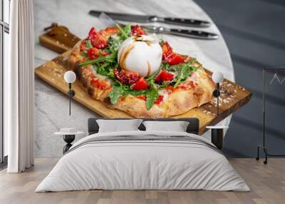 Italian focaccia with burrata and zucchini flower with tomatoes cherry and ham, flatlay top view composition, on a black background Wall mural