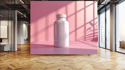 A white bottle with a white lid sits on a pink table with a soft pink backdrop. The sunlight coming through the window casts a shadow of a leafy plant on the wall. Wall mural