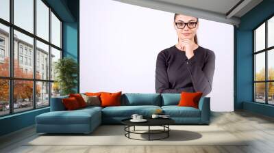 beautiful young businesswoman standing with crossed arms and smiling at camera in office Wall mural