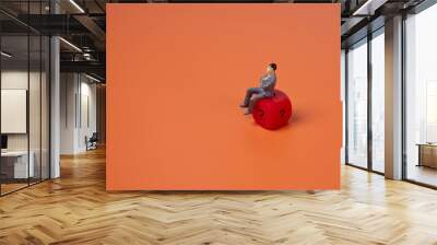 Businessman sitting on red dice with a question mark on orange background. Copy space for text. Luck, risk and choice concept. Wall mural