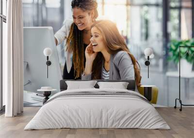 that's unbelievable. cropped shot of two attractive young businesswomen working at a desk in their o Wall mural