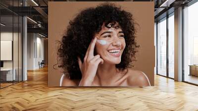 Black woman, facial cream and skincare wellness of happy face skin glow and sunscreen. Cosmetic, collagen and dermatology lotion of a woman model with a smile from natural cosmetics treatment Wall mural