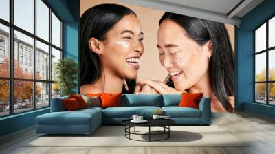 Happy, beauty and skincare women with cream for face isolated on a beige studio background. Wellness, smile and Asian model friends with sunscreen for love of cosmetics and dermatology on a backdrop Wall mural