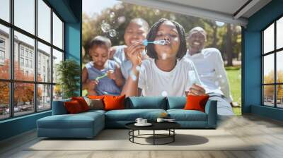 Happy, nature and black family blowing bubbles while playing, bonding and enjoying summer in the park. Happiness, father and mother with children having fun together in a green garden in South Africa Wall mural