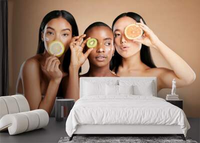 Skincare, diversity and women with fruit, cosmetics and dermatology with friends on brown studio background. Face, vitamin c or ladies with natural beauty, girls and nutrition with healthy lifestyle Wall mural