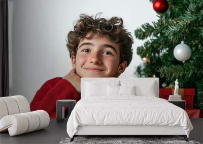 On Christmas Day, An European or American faces boy dressed in new clothes,smiles as presents are placed next to the Christmas tree as he waits for Christmas Eve during the festive season. Wall mural