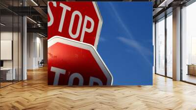 Two stop signs on blue sky Wall mural