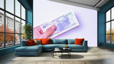 Indonesian Rupiah the official currency of Indonesia. Male hand showing Indonesian Rupiah note. Business Investment Economy Money and Finance Concept Uang 1000 Rupiah Kuno Vintage and ancient concept. Wall mural