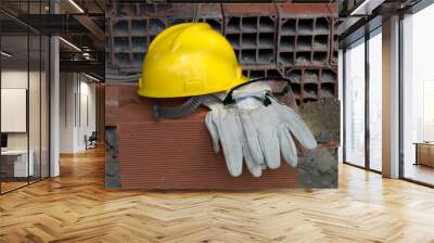 Gloves, helmet and mason's goggles on pile of bricks Wall mural