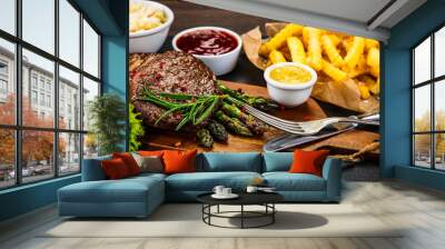 Barbecue beef steak french fries and vegetables on black stone Wall mural