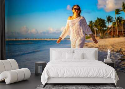 Beach holiday - beautiful woman walking on sunny, tropical beach 
 Wall mural