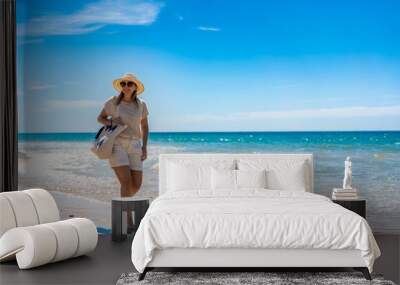 Beautiful woman walking on sunny beach
 Wall mural