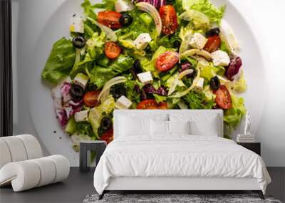 Fresh greek salad on a plate on white background Wall mural