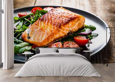 Fried salmon steak with vegetables on wooden table Wall mural