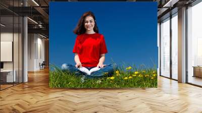 Girl reading book sitting outdoor Wall mural