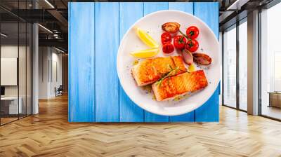 Grilled salmon with vegetables on white plate Wall mural