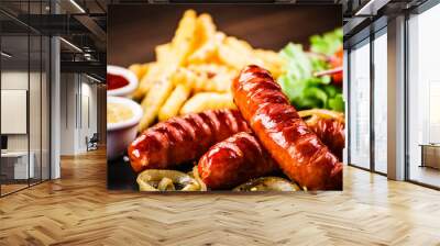 Grilled sausages, French fries and vegetables Wall mural