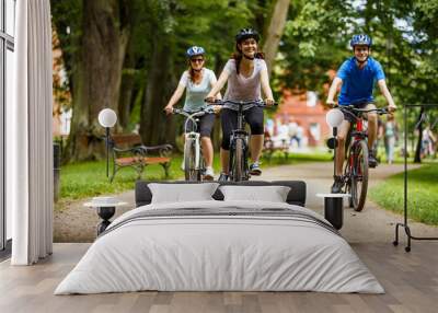 Healthy lifestyle - people riding bicycles in city park  Wall mural