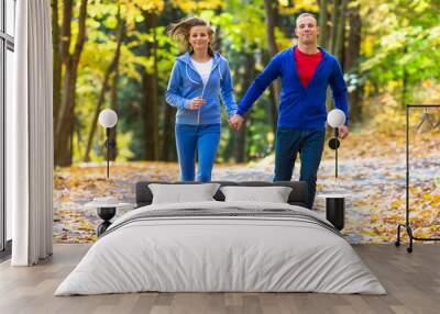 Healthy lifestyle - woman and man running in park Wall mural